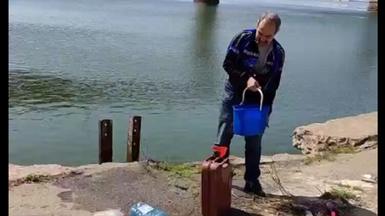 Люди из реки набирают воду. Скриншот из видео